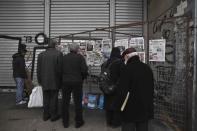 People read newspaper headlines in central Athens, February 12, 2015. REUTERS/ Alkis Konstantinidis
