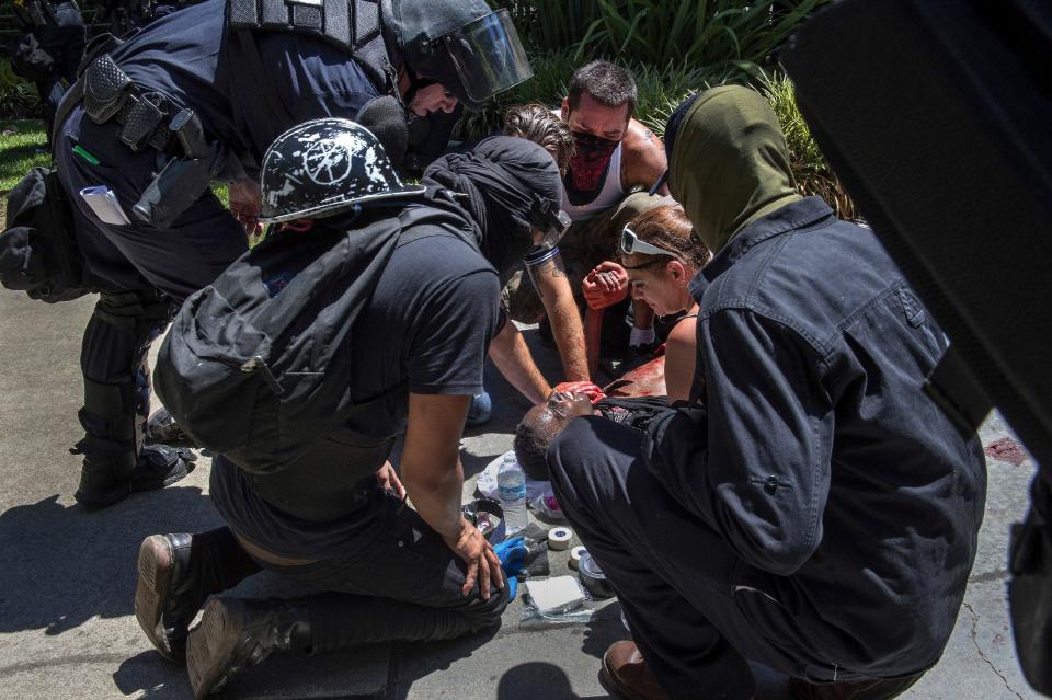 A stabbing victim is attended to during a neo-Nazi rally in Sacramento, Calif.