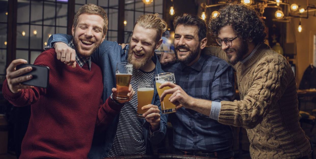 happy gatherings at the pub group of happy young men taking a selfie while drinking beer