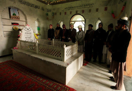 Men pray over the grave of Mumtaz Qadri, the man Pakistan executed last year for assassinating a governor who proposed reforming the country’s blasphemy laws, during their visit to Qadri's shrine on the outskirts of Islamabad, Pakistan, January 5, 2017. Picture taken January 5, 2017. REUTERS/Faisal Mahmood