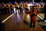 <p>Amarion Allen, 11-years-old, stands in front of a police line shortly before shots were fired in a police-officer involved shooting in Ferguson, Missouri August 9, 2015. Two people were shot in the midst of a late-night confrontation between riot police and protesters, after a day of peaceful events commemorating the fatal shooting of Michael Brown by a white officer one year ago. (Rick Wilking/Reuters) </p>