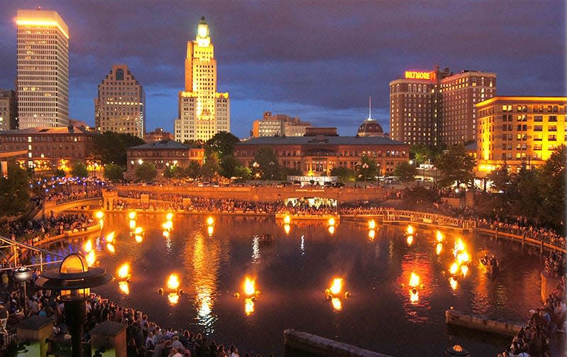 An early evening view of a WaterFire Providence lighting in June 2013, looking south, with Waterplace Park's reflecting pool – a nod to the history of the Providence Cove – in the foreground.