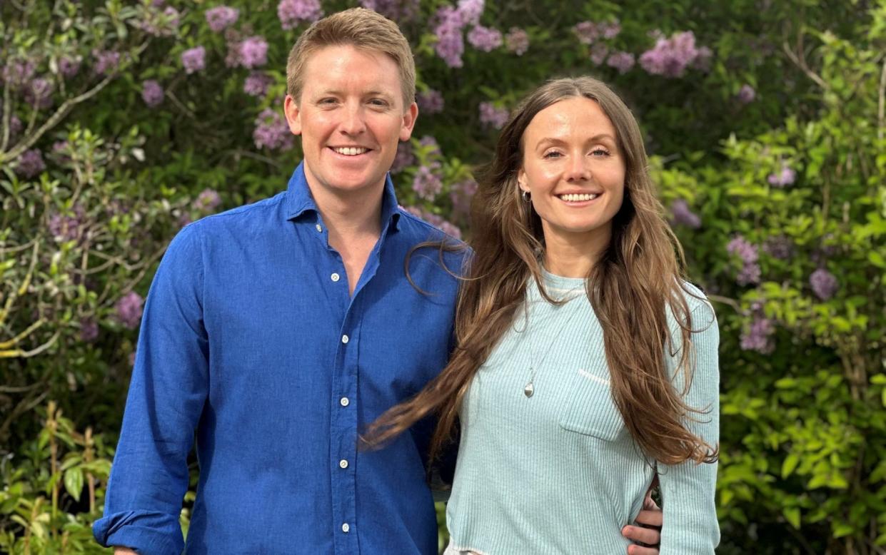 The young couple stand together in a garden