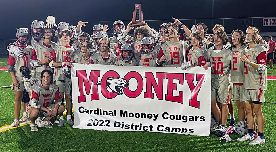 The Cardinal Mooney Catholic boys lacrosse team holds the trophy and the district championship banner after defeating Saint Stephen's, 18-7, in the Class 1A-District 11 final Thursday night at John Heath Field at Austin Smithers Stadium.