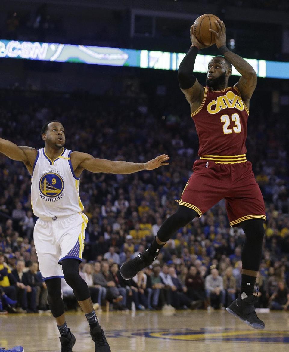 Cleveland Cavaliers' LeBron James, right, shoots over Golden State Warriors' Andre Iguodala (9) during the first half of an NBA basketball game, Monday, Jan. 16, 2017, in Oakland, Calif. (AP Photo/Ben Margot)