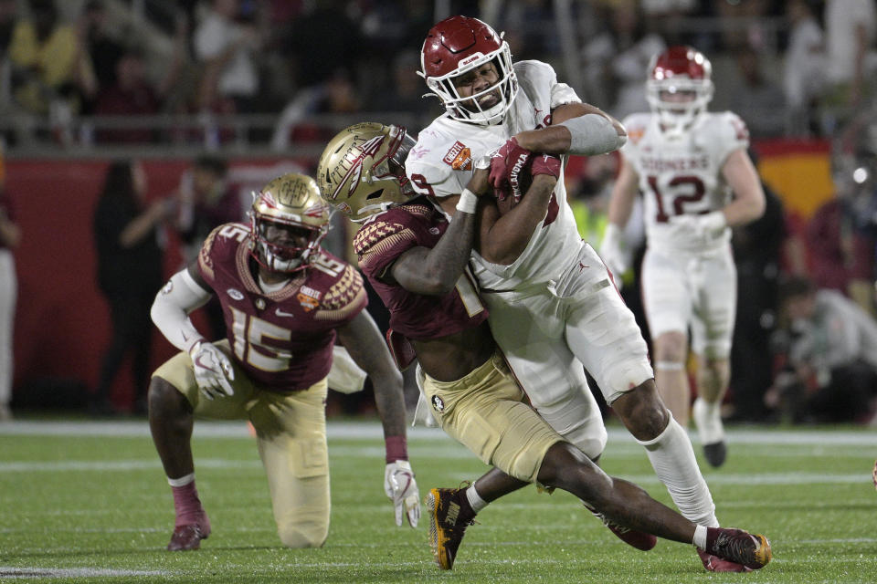 Oklahoma tight end Brayden Willis (9) is pulled down by Florida State defensive back Jammie Robinson (10) after catching a pass during the second half of the Cheez-It Bowl NCAA college football game Thursday, Dec. 29, 2022, in Orlando, Fla. (AP Photo/Phelan M. Ebenhack)