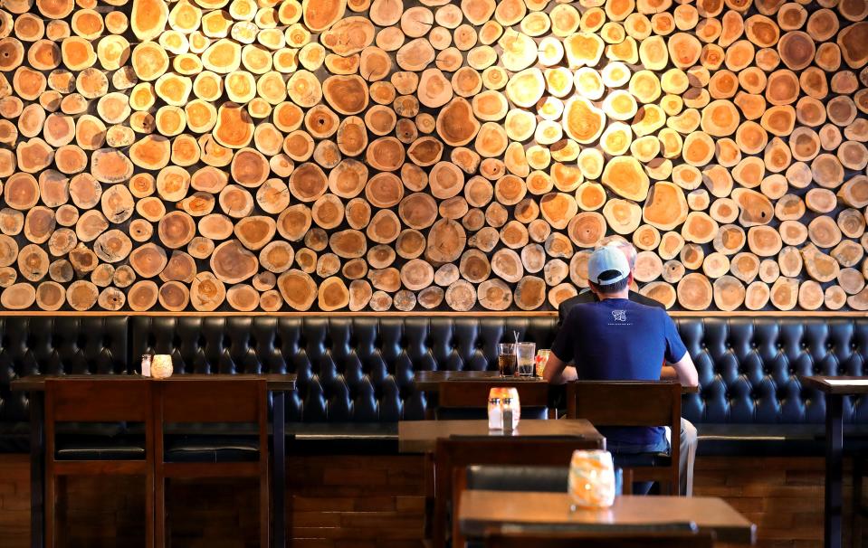 Patrons dine in front of a wood-covered wall at Town Tavern Wednesday, Sept. 20, 2023, in Copley, Ohio.