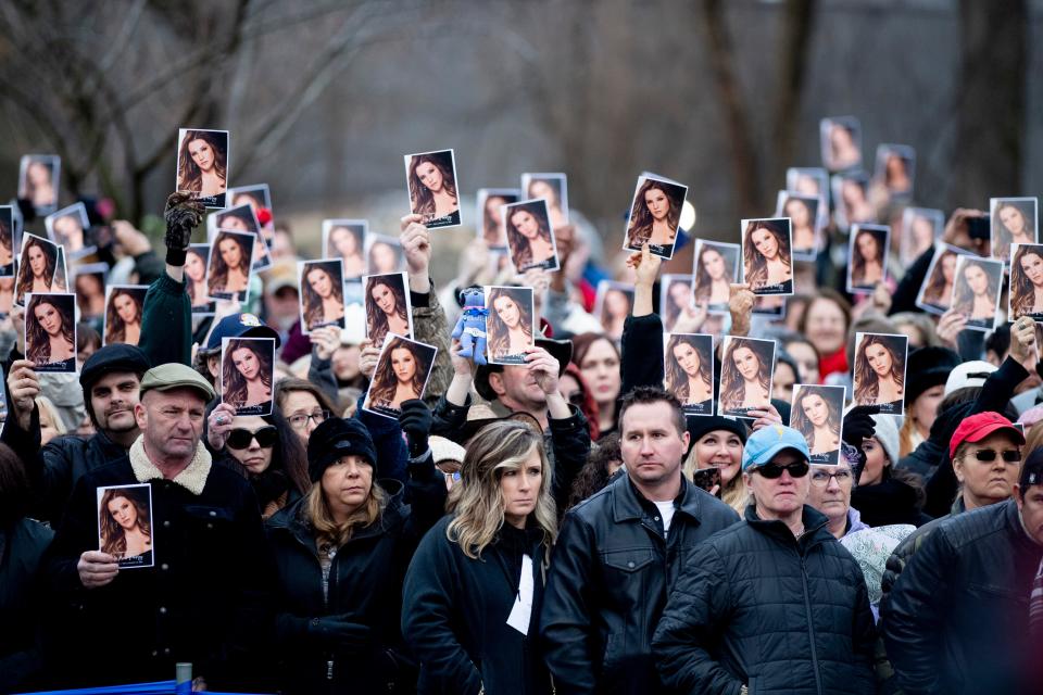 Mourners hold up a program with a photo of Lisa Marie Presley on the front lawn of Graceland at the end of the celebration of life for Lisa Marie Presley in Memphis, Tenn., on Sunday, January 22, 2023. 