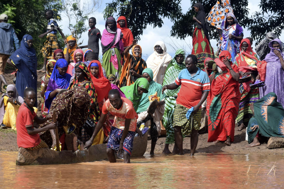 Residents of Chamwana Muma village take a canoe to cross the swollen River Tana, in Tana Delta, Kenya, on Wednesday Nov. 15, 2023. Unrelenting rainfall across Kenya's northern counties and the capital, Nairobi, has led to widespread flooding, displacing an estimated 36,000 people and killing 46 people since the beginning of the rainy season less than a month ago. (AP Photo/Gideon Maundu).