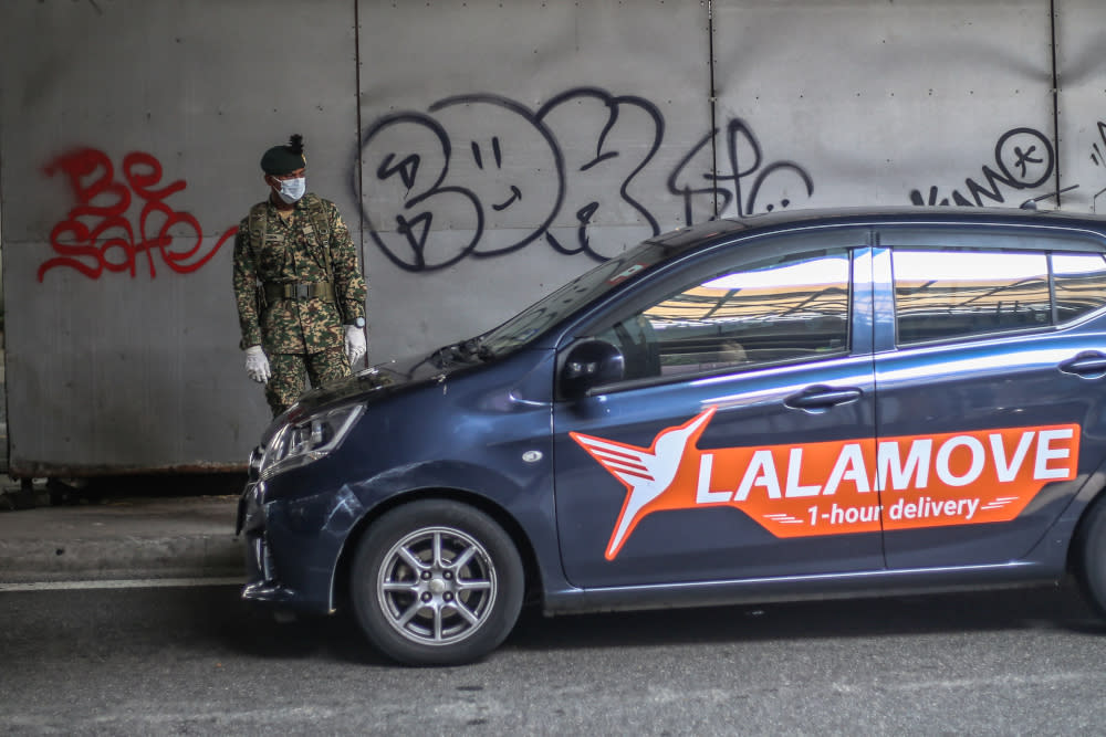 Soldiers and police officers conducting checks at a roadblock on day five of the movement control order (MCO) at Jalan Loke Yew in Kuala Lumpur March 22, 2020. — Picture by Firdaus Latif