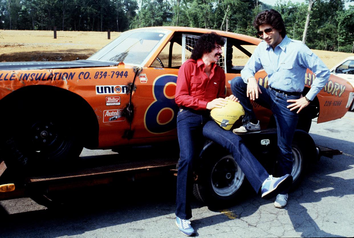 Members of the Oak Ridge Boys, Joe Bonsall, left, and Richard Sterban show off one of the racing cars June 7, 1982, that will be used in the race. They are among the country music stars who entered a special Fan Fair race at Nashville Raceway.