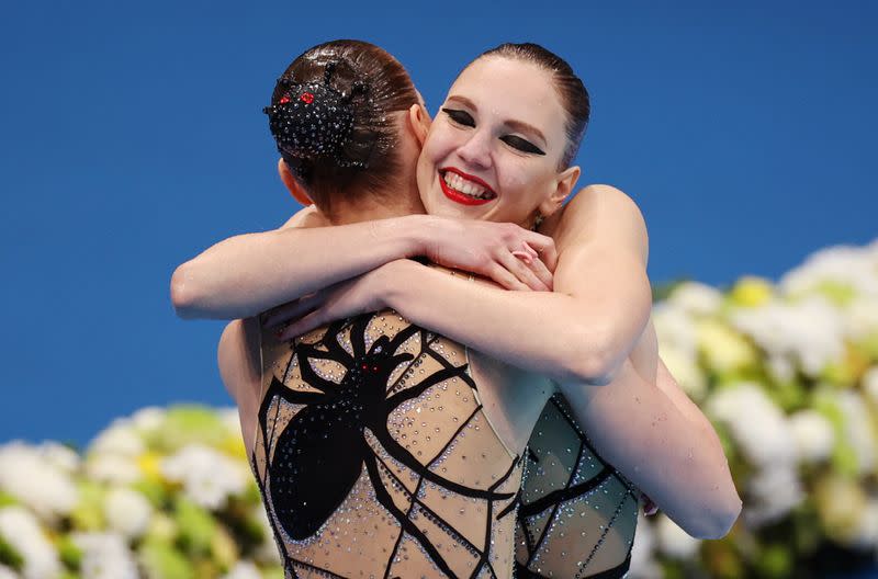 Foto del miércoles de las rusas Svetlana Kolesnichenko y Svetlana Romashina celebrando tras ganar la final de la prueba de nado sincronizado por parejas.