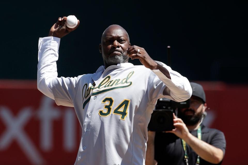 Former Oakland Athletics player Dave Stewart throws out the ceremonial first pitch before a baseball game between the Athletics and the San Francisco Giants in Oakland, Calif., Sunday, Aug. 25, 2019. (AP Photo/Jeff Chiu)