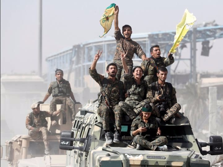 Syrian Democratic Forces (SDF) fighters ride atop of military vehicles as they celebrate victory in Raqqa, Syria, October 17, 2017. REUTERS/Erik De Castro