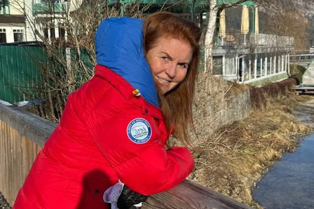 Sarah Ferguson shared a photo of herself smiling and dressed a vivid red warm winter coat while leaning on a small bridge over a river, apparently in Austria (Instagram)