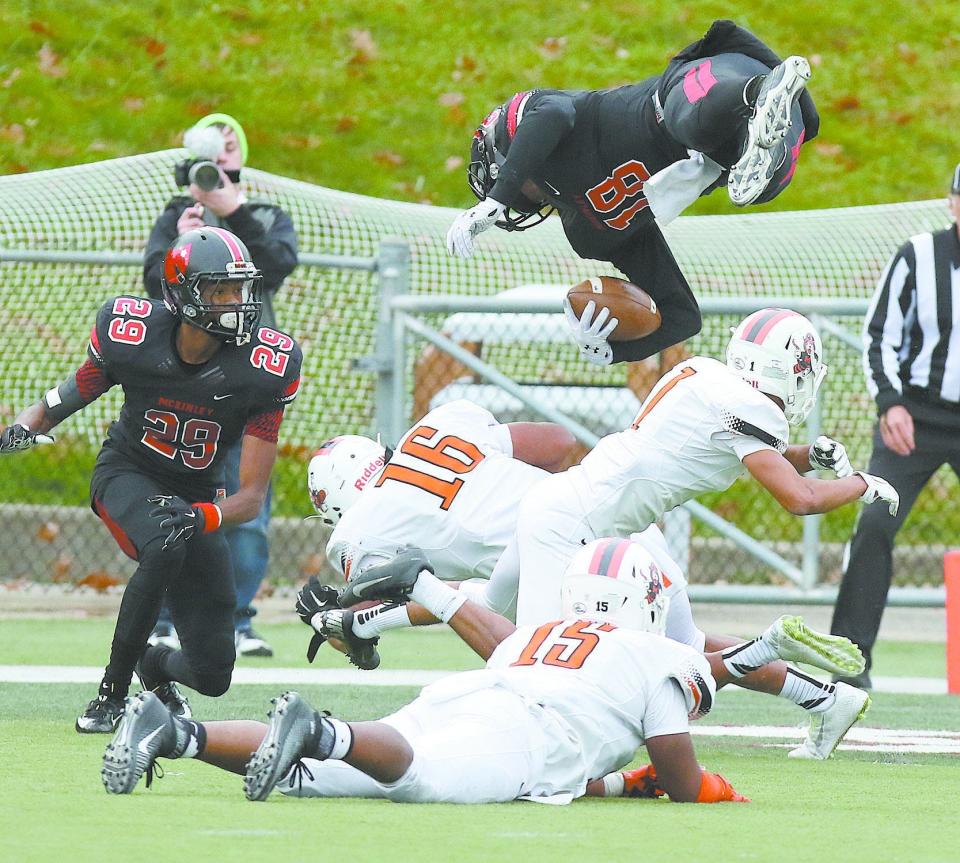 McKinley quarterback Dominique Robinson goes up and over Masssillon's Jamir Thomas, 16, Jeff Koch,1, and Ra'Jon Anthony ,15, for the decisive fourth-quarter touchdown to put the Bulldogs ahead 30-28 in 2015.