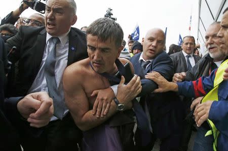 File photo of a shirtless Xavier Broseta (2ndL), Executive Vice President for Human Resources and Labour Relations at Air France, who was evacuated by security after employees interrupted a meeting with representatives staff at the Air France headquarters building at the Charles de Gaulle International Airport in Roissy, near Paris, France, in this picture taken October 5, 2015. REUTERS/Jacky Naegelen/File Photo