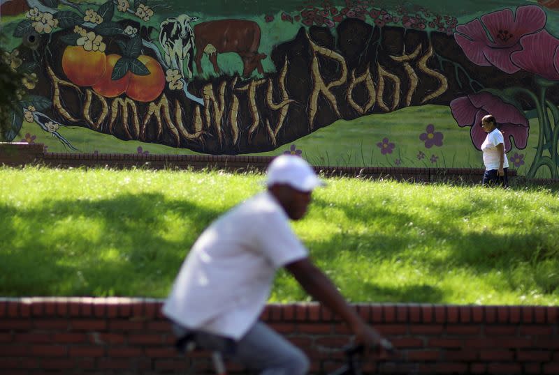 A woman walks past a mural in the Lozells area of Birmingham