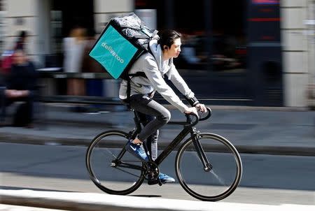 A cyclist rides a bicyle as he delivers food for Deliveroo, an example of the emergence of what is known as the 'gig economy', in Paris, France, April 7, 2017. Picture taken April 7, 2017. REUTERS/Charles Platiau