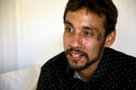 Eric Martinez is interviewed in his room at a micro community in Denver on Wednesday, June 5, 2024. Martinez along with the others were directed into the micro communities of small cabin-like structures with a twin bed, desk and closet, after his Denver tent encampment was swept. The city built three such communities with nearly 160 units total in about six months, at roughly $25,000 per unit. (AP Photo/Thomas Peipert)