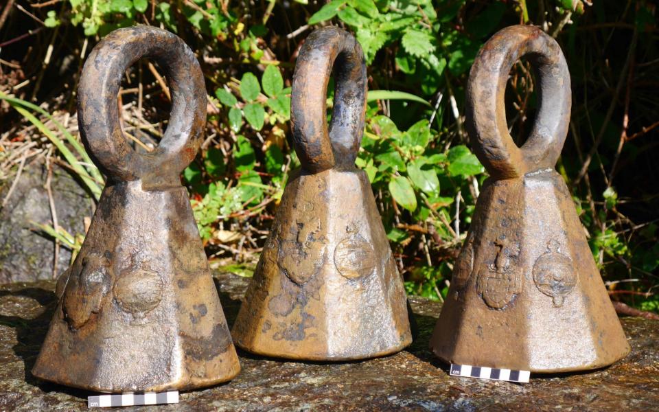 Three 25.4 kg bronze weights from the wreck of the Schiedam with the Portuguese Royal coat of arms visible on the side - David Gibbins