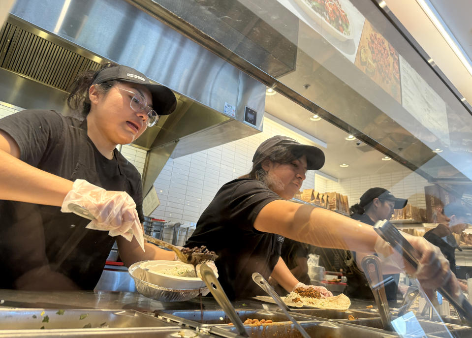 SAN RAFAEL, CALIFORNIA - APRIL 1: Employees fill food orders at a Chipotle restaurant on April 1, 2024 in San Rafael, California. A new minimum wage law went into effect today in California, requiring fast-food restaurants with at least 60 locations nationwide to pay their employees at least $20 an hour in their California stores. (Photo by Justin Sullivan/Getty Images)
