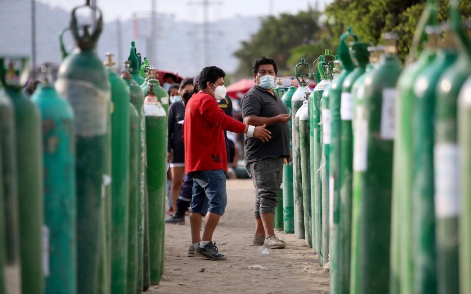 Buyers talk while waiting for their oxygen tanks to be filled in Lima, Peru - Raul Sifuentes/Getty Images South America