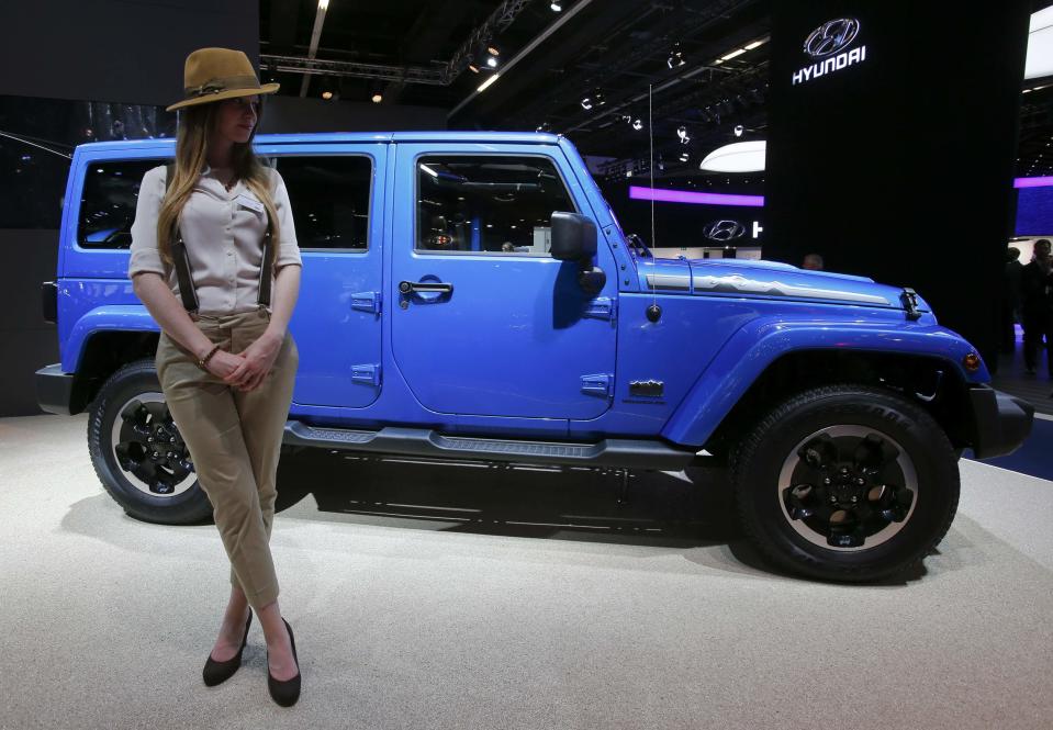 A model poses next to a Jeep Wrangler Unlimited during a media preview day at the Frankfurt Motor Show