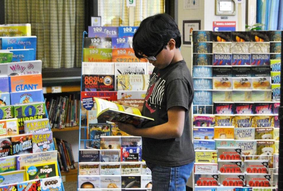 Ramses Calderon, a 5th-grader at Wendell Elementary, chooses a book at the school’s book fair in this 2015 file photo.