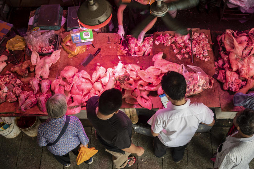 A customer picks out a pig ear at a pork stall inside the Dancun Market in Nanning, Guangxi province, China. Source: Getty