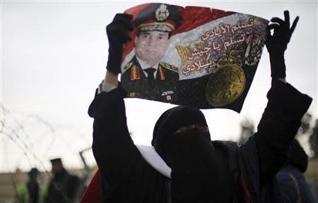 A supporter of Egypt's army chief Field Marshal Abdel Fattah al-Sisi shout slogans while holding a poster of him outside a police academy, where the trial of ousted Egyptian President Mohamed Mursi and members of the Muslim Brotherhood is due to take place, on the outskirts of Cairo, February 16, 2014. REUTERS/Amr Abdallah Dalsh