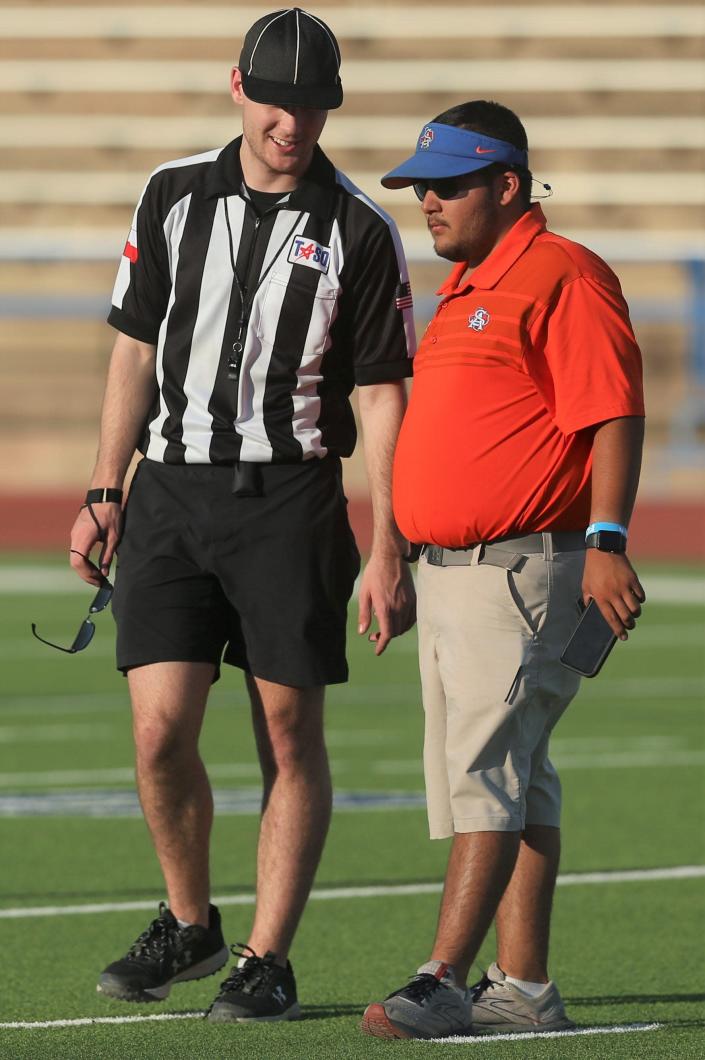 Volunteer assistant River Subia talks with an official during San Angelo Central High School's spring football game at San Angelo Stadium on Wednesday, May 18, 2022.