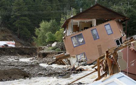 A destroyed house with one of its walls still clinging on is seen in Jamestown, Colorado, after a flash flood destroyed much of the town, September 14, 2013. REUTERS/Rick Wilking