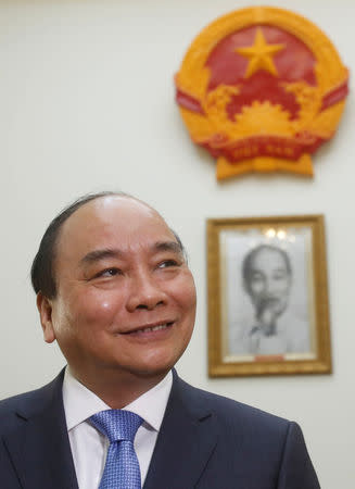 Vietnam's Prime Minister Nguyen Xuan Phuc is seen in front of an image of late Vietnamese revolutionary leader Ho Chi Minh and the Vietnam emblem during an interview at the Government Office in Hanoi, Vietnam May 25, 2016. REUTERS/Kham