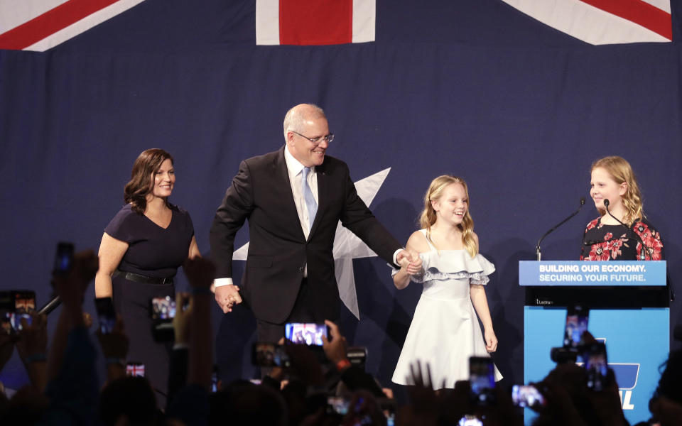 Australian Prime Minister Scott Morrison, second left, arrives on stage to speak to party supporters flanked by his wife, Jenny, left, and daughters Lily, and Abbey, right, after his opponent conceded in the federal election in Sydney, Australia, Sunday, May 19, 2019. Australia's ruling conservative coalition, lead by Morrison, won a surprise victory in the country's general election, defying opinion polls that had tipped the center-left opposition party to oust it from power and promising an end to the revolving door of national leaders. (AP Photo/Rick Rycroft)