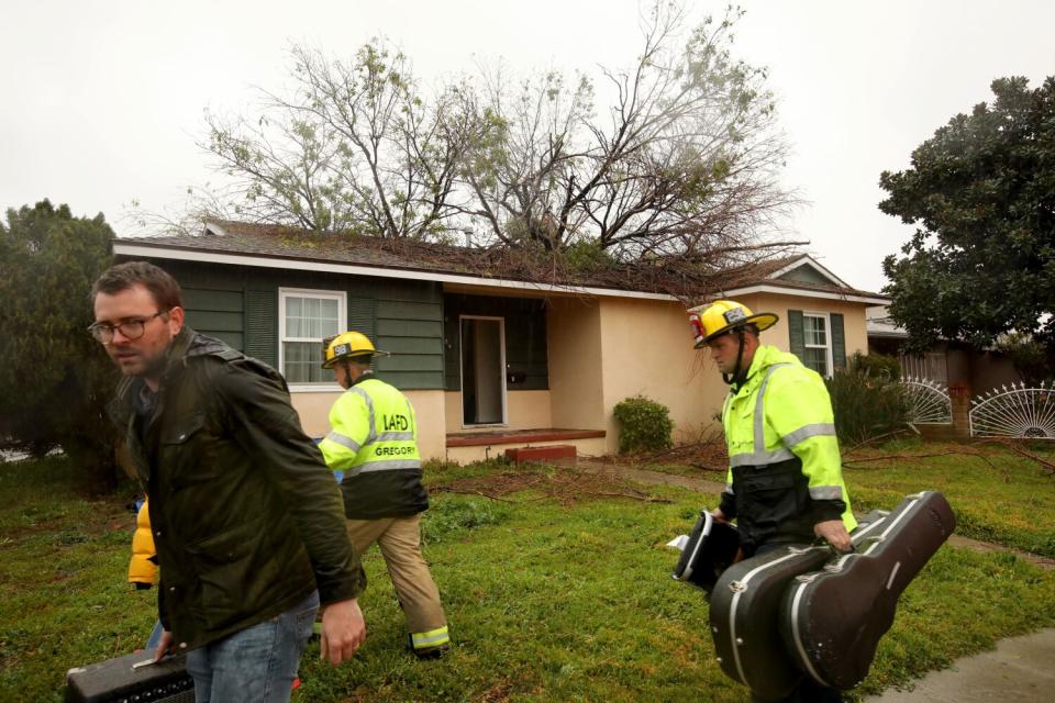 LAFD firefighters help a homeowner evacuate belongings in Panorama City.