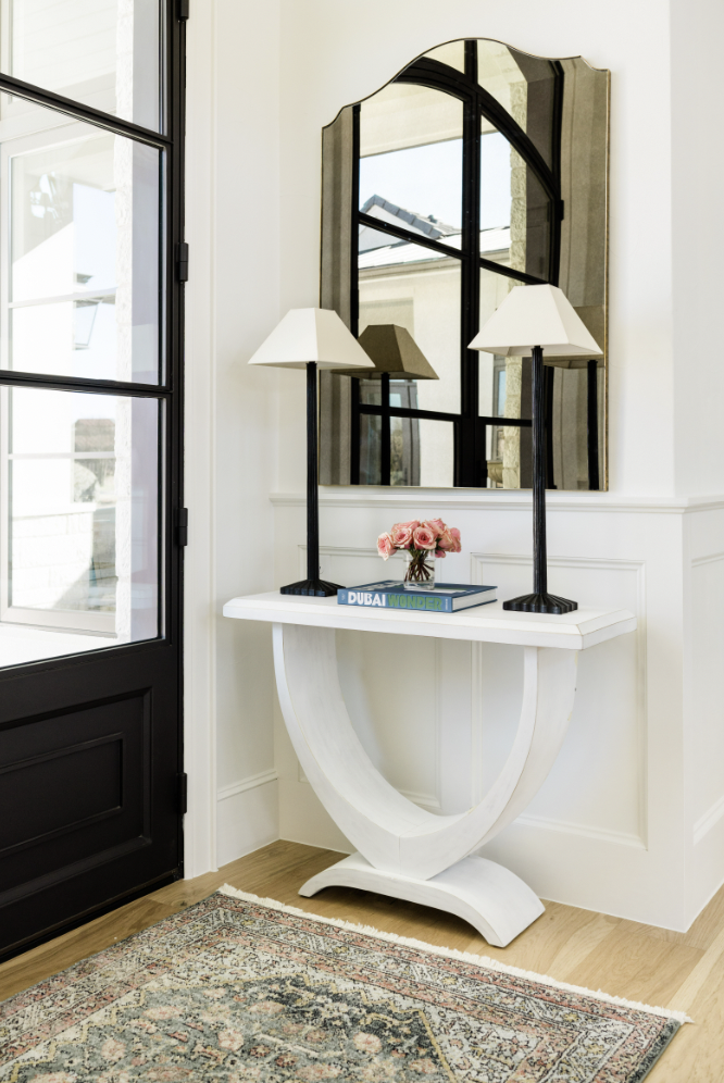 a white table with a mirror and two lamps