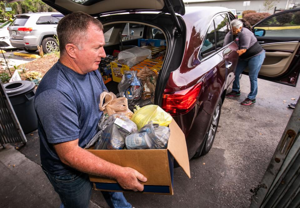 Retired postal worker Timothy Legge helps unload donated food from a vehicle that pulled up to Interfaith Emergency Services on May 3.