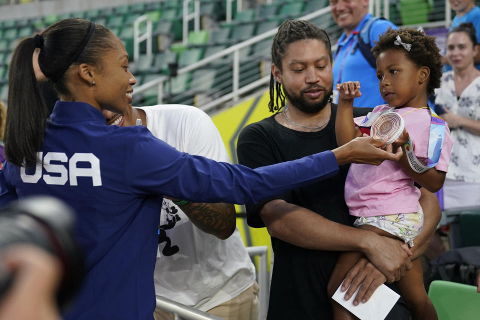 Allyson Felix, of the United States, gives her daughter Camryn her bronze medal after the 4x400-meter mixed relay final at the World Athletics Championships Friday, July 15, 2022, in Eugene, Ore. (AP Photo/Charlie Riedel)