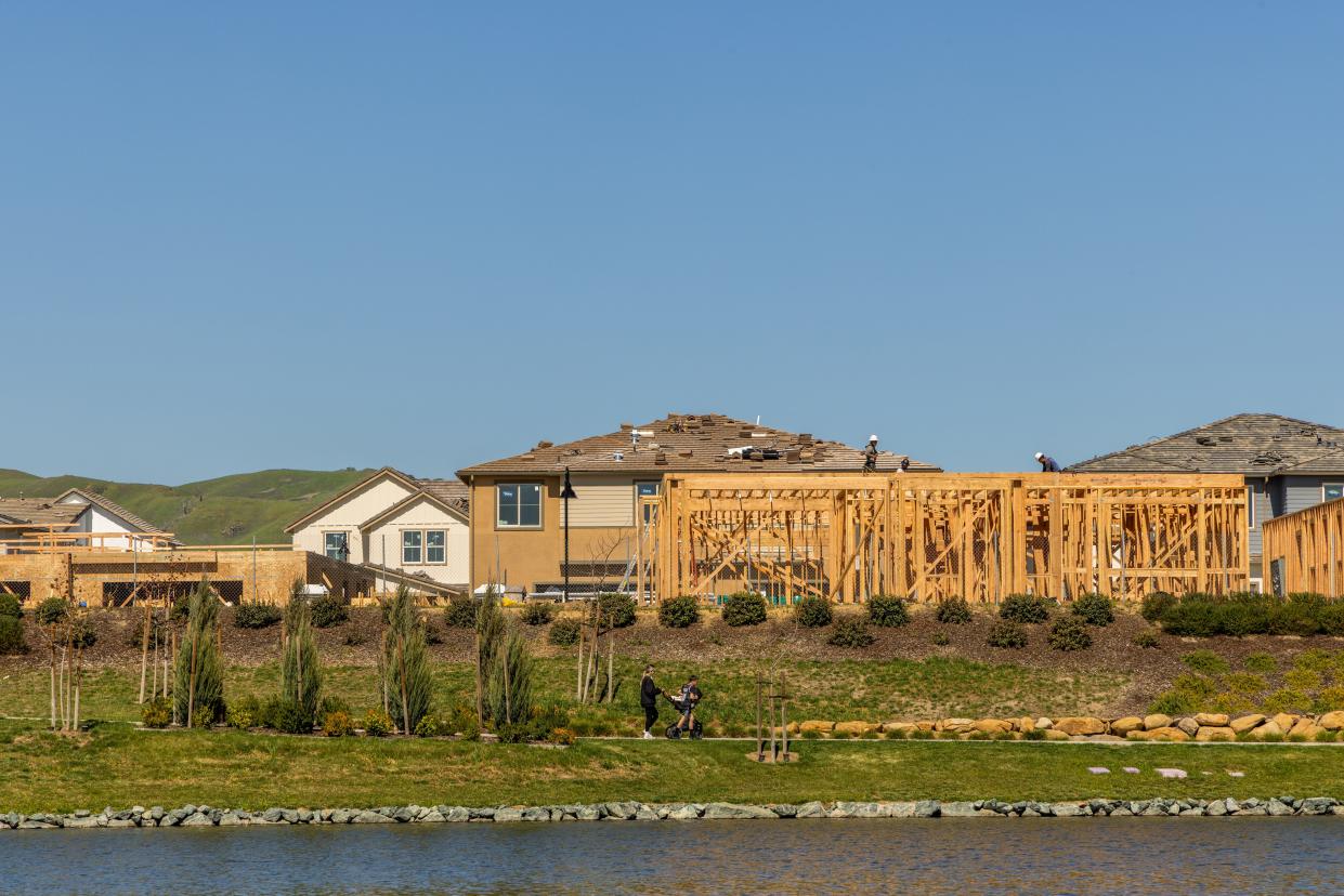 One Lake neighborhood with houses being built in front of a man-made river.