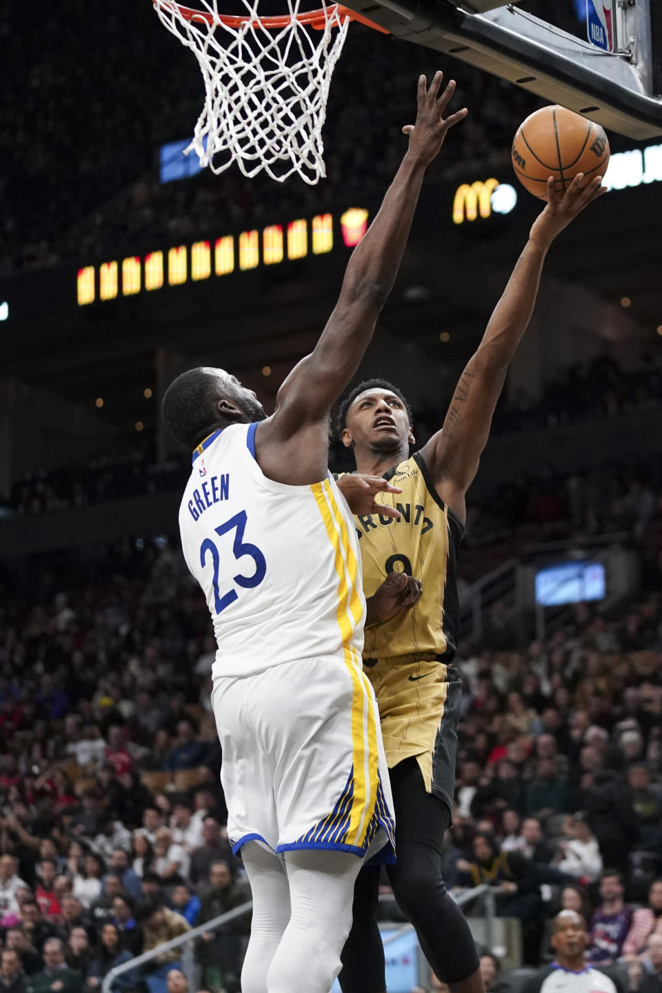 Toronto Raptors guard RJ Barrett (9) shoots as Golden State Warriors forward Draymond Green (23) defends during the second half of an NBA basketball game Friday, March 1, 2024, in Toronto. (Arlyn McAdorey/The Canadian Press via AP)