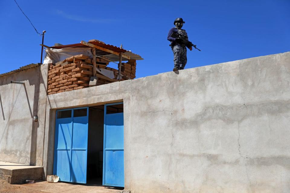 A police officer stands guard at an outpost