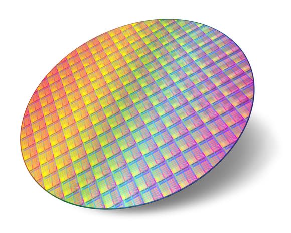 An uncut circular wafer of semiconductor chips in the making.
