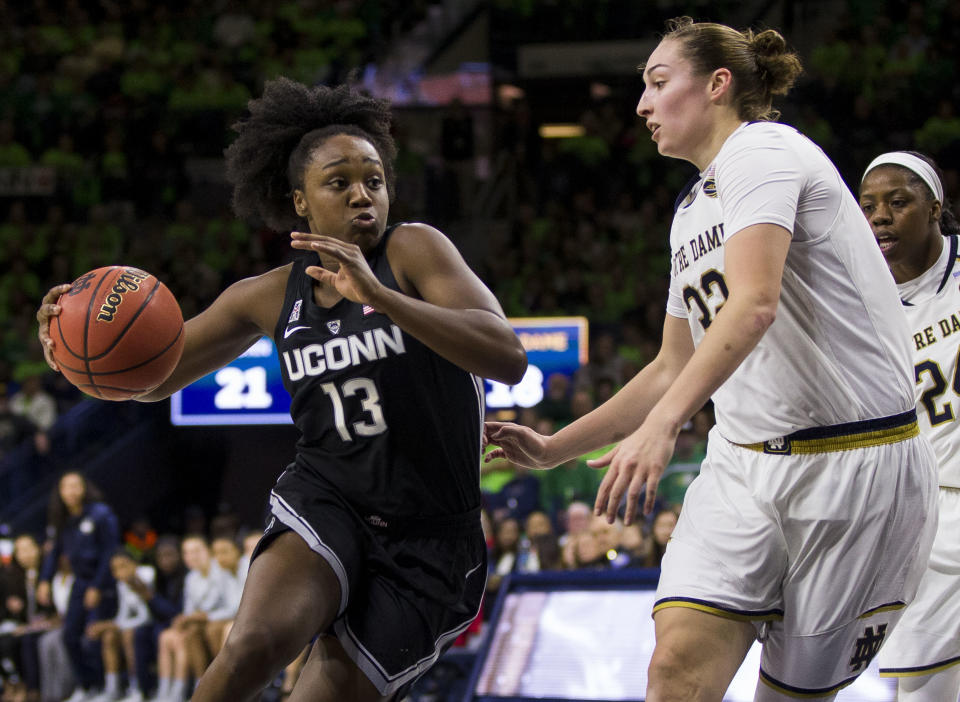 Connecticut's Christyn Williams (13) drives in next to Notre Dame's Jessica Shepard (32) during the first half of an NCAA college basketball game Sunday, Dec. 2, 2018, in South Bend, Ind. (AP Photo/Robert Franklin)