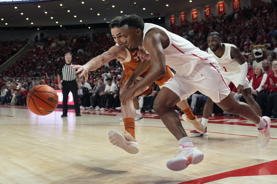 Houston's L.J. Cryer, right, and Texas' Brock Cunningham reach for a loose ball during the second half of an NCAA college basketball game Saturday, Feb. 17, 2024, in Houston. Houston won 82-61. (AP Photo/David J. Phillip)