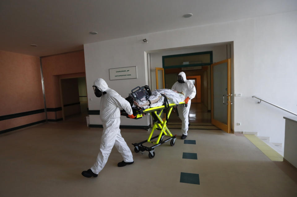 Health care workers transport a COVID-19 patient from an intensive care unit (ICU) at a hospital in Kyjov to hospital in Brno, Czech Republic, Thursday, Oct. 22, 2020. With cases surging in central Europe, some countries are calling in soldiers, firefighters, students and retired doctors to help shore up buckling health care systems. Many faced a shortage of medical personnel even before the pandemic, and now the virus has sickened many health workers, compounding the shortfall. (AP Photo/Petr David Josek)