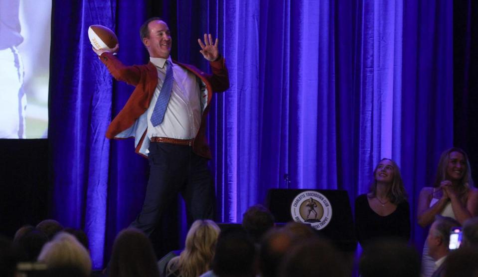 Peyton Manning throws a football to an attendee of the Charlotte Touchdown Club speaker series luncheon at the Sheraton Charlotte Hotel on Thursday, April, 25, 2024.
