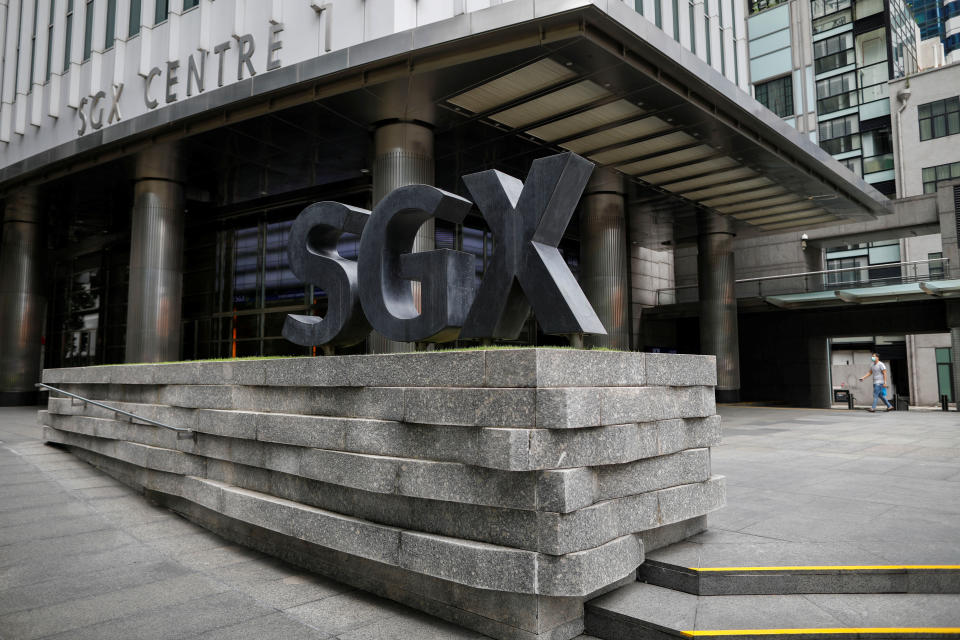 A man wearing a protective face mask walks past the Singapore Exchange (SGX) which stays open during "circuit breaker" measures to curb coronavirus COVID-19) in central business district area in Singapore, April 7, 2020. REUTERS/Edgar Su