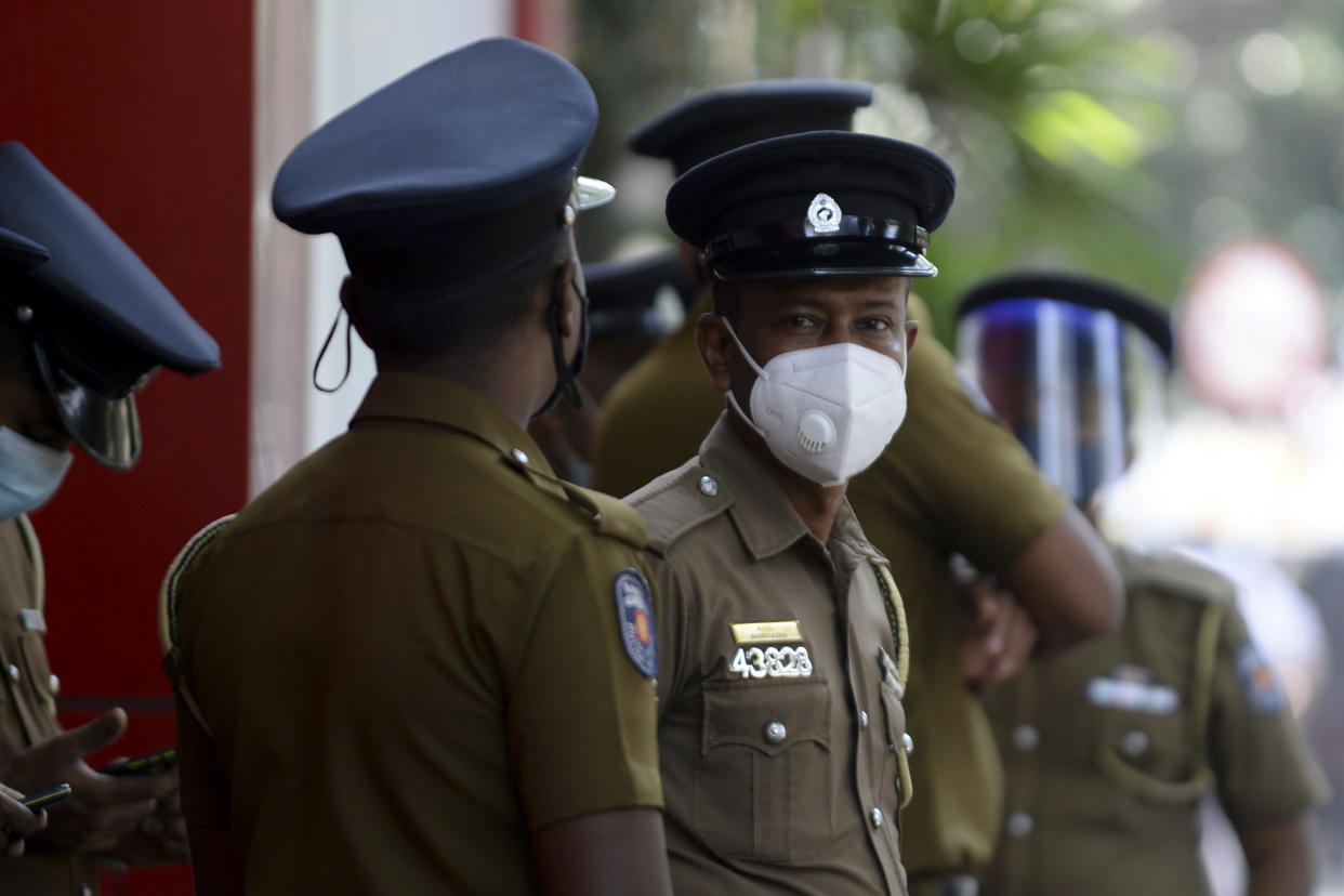 Sri Lankan police personnel stand along a road in Colombo on January 26, 2021. (Photo by LAKRUWAN WANNIARACHCHI / AFP) (Photo by LAKRUWAN WANNIARACHCHI/AFP via Getty Images)