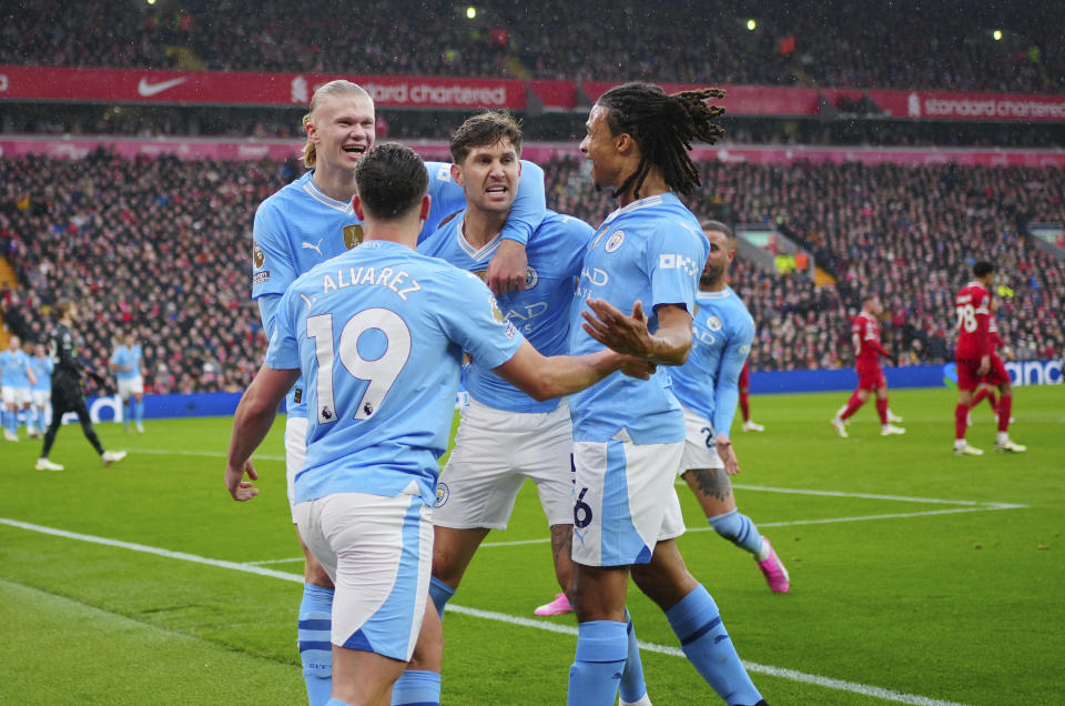 Manchester City's John Stones, center, celebrates with teammates after scoring the opening goal of his team during the English Premier League soccer match between Liverpool and Manchester City, at Anfield stadium in Liverpool, England, Sunday, March 10, 2024. (AP Photo/Jon Super)